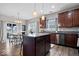 Modern kitchen with stainless steel appliances, dark cabinets, granite countertops, and an island with seating, perfect for cooking and dining at 15332 Atkinson Dr, Noblesville, IN 46060