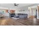 Cozy living room with hardwood floors, a comfortable gray sectional, and an open layout leading to the kitchen, perfect for Gathering gatherings at 15332 Atkinson Dr, Noblesville, IN 46060