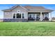 Expansive backyard features a covered patio, lush green lawn, stone accents, and a calming atmosphere at 15882 Vitalize Run, Fishers, IN 46040