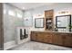 Luxurious primary bath with double sinks, custom wood cabinets, and a tiled walk-in shower at 15882 Vitalize Run, Fishers, IN 46040