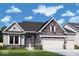Beautiful new construction home featuring stone accents, a three-car garage and manicured front lawn at 15882 Vitalize Run, Fishers, IN 46040