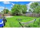 A spacious backyard with a hammock, partially fenced and featuring a lush green lawn with scattered trees at 1641 Iowa St, Indianapolis, IN 46203