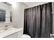 Bathroom featuring a sink, toilet, mirror and shower with dark curtain at 1641 Iowa St, Indianapolis, IN 46203