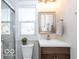 This is a bathroom with a sliding glass shower, a modern vanity, and a large mirror at 1641 Iowa St, Indianapolis, IN 46203