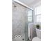 This bathroom has a glass shower stall with marble-look tiles and a window for natural light at 1641 Iowa St, Indianapolis, IN 46203