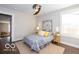 This bedroom features a ceiling fan, a queen size bed with gray and white floral bedding, and tan carpet at 1641 Iowa St, Indianapolis, IN 46203