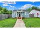 Charming light blue house with a black door, inviting front porch, and a well-maintained lawn at 1641 Iowa St, Indianapolis, IN 46203