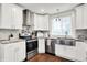 Bright kitchen features white cabinets, stainless steel appliances, and a farmhouse sink under a window at 1641 Iowa St, Indianapolis, IN 46203