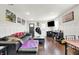 Open-concept living room with modern finishes, sleek furniture, wood floors, and a large television at 1641 Iowa St, Indianapolis, IN 46203