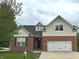 Charming two-story home featuring a brick facade, two car garage and a well-manicured lawn at 18680 Long Walk Ln, Noblesville, IN 46060