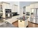 Bright kitchen featuring white cabinets, a center island, and stainless steel appliances at 18680 Long Walk Ln, Noblesville, IN 46060