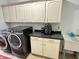 Well-equipped laundry room with front load washer and dryer and ample cabinet space at 18680 Long Walk Ln, Noblesville, IN 46060