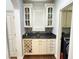 Wet bar featuring a wine rack, cabinets with glass doors and tiled backsplash at 18680 Long Walk Ln, Noblesville, IN 46060