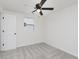 This carpeted bedroom includes a ceiling fan, a window and a white door at 1906 N Park Ave, Indianapolis, IN 46202
