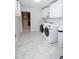 Bright laundry room featuring a front load washer and dryer, white cabinets, and neutral flooring at 1970 E 1100 N, Alexandria, IN 46001