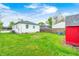 Expansive backyard featuring a grassy lawn and a charming red shed, perfect for outdoor activities at 2021 Reformers Ave, Indianapolis, IN 46203