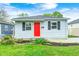 Charming single-story home with a bright red door, tidy landscaping, and neutral siding at 2021 Reformers Ave, Indianapolis, IN 46203
