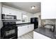 Modern kitchen with white cabinetry, black appliances, and sleek countertops for a clean look at 2021 Reformers Ave, Indianapolis, IN 46203