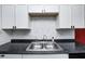 Close-up of a double basin stainless steel sink with a gooseneck faucet and marble backsplash at 2021 Reformers Ave, Indianapolis, IN 46203