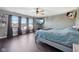 Spacious bedroom with dark wood floors, ceiling fan, TV, and ample natural light at 2116 Crimson Ln, Lebanon, IN 46052