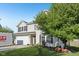 Two-story home with a well-manicured lawn, attached garage, and a beautiful tree with decorative foxes at 2116 Crimson Ln, Lebanon, IN 46052