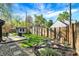 Landscaped backyard featuring a wooden fence, shed, grassy area, patio, and garden providing a serene outdoor space at 2221 Douglas Rd, Indianapolis, IN 46220