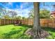 Fenced backyard with a fire pit area, string lights overhead, a large tree and lush green grass at 2221 Douglas Rd, Indianapolis, IN 46220