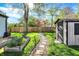 Well-manicured backyard featuring a shed, stepping stone path, raised garden, and a wooden privacy fence at 2221 Douglas Rd, Indianapolis, IN 46220
