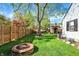 Spacious backyard featuring a fire pit with wood, and a wooden fence, offering an inviting outdoor retreat at 2221 Douglas Rd, Indianapolis, IN 46220