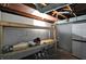 The unfinished basement contains a workbench area for projects at 2221 Douglas Rd, Indianapolis, IN 46220