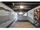 The unfinished basement featuring painted walls and ceiling with concrete floors covered by a large area rug at 2221 Douglas Rd, Indianapolis, IN 46220