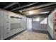 A view of the unfinished basement showing built in storage and a rug on the floor at 2221 Douglas Rd, Indianapolis, IN 46220