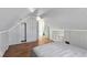 Attic bedroom featuring hardwood floors and gray paneled walls at 2221 Douglas Rd, Indianapolis, IN 46220