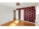 Bedroom features hardwood floors, a modern light fixture, and a unique accent wall at 2221 Douglas Rd, Indianapolis, IN 46220
