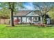 Charming blue home with a well-manicured lawn and inviting front entrance and covered bench at 2221 Douglas Rd, Indianapolis, IN 46220