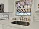 Kitchen sink with quartz counters, bronze fixtures and window view at 2221 Douglas Rd, Indianapolis, IN 46220