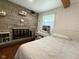 Bedroom featuring a stone fireplace, wood flooring, and natural light at 2350 Brewer Dr, Indianapolis, IN 46227