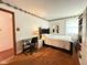 Bedroom with orange carpet, bed, desk and floral wallpaper at 2350 Brewer Dr, Indianapolis, IN 46227