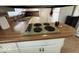 Cozy kitchen countertop features vintage electric cooktop, with sink and cabinets in background at 2350 Brewer Dr, Indianapolis, IN 46227