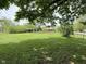 Lush backyard with large grassy area, mature trees, and ample space for recreation at 2350 Brewer Dr, Indianapolis, IN 46227
