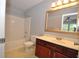 Bathroom with a vanity with cherry cabinets, framed mirror, and shower and tub combination at 2363 N Pennsylvania St, Indianapolis, IN 46205