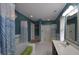 Stylish bathroom with teal walls, white tile, shower and tub with a glass door at 2363 N Pennsylvania St, Indianapolis, IN 46205