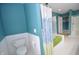 Bright bathroom with a shower and tub combination, white tile floor, and blue accent walls at 2363 N Pennsylvania St, Indianapolis, IN 46205