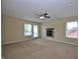 A bright bedroom features a ceiling fan, fireplace, neutral carpet, and windows for natural light at 2363 N Pennsylvania St, Indianapolis, IN 46205