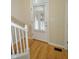 A bright entryway features hardwood floors, a white door with window, and a white staircase at 2363 N Pennsylvania St, Indianapolis, IN 46205