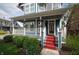 Charming front porch with decorative columns, manicured shrubs, and a red door creating a warm and inviting entrance at 2363 N Pennsylvania St, Indianapolis, IN 46205