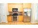 Modern kitchen with stainless steel appliances, wood cabinets, and tile backsplash at 2363 N Pennsylvania St, Indianapolis, IN 46205