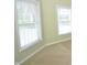 Corner view of a light green living room featuring neutral carpet and two bright windows with white blinds at 2363 N Pennsylvania St, Indianapolis, IN 46205