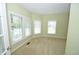 Bright living room with neutral carpet and ample natural light from three large windows with white blinds at 2363 N Pennsylvania St, Indianapolis, IN 46205