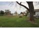 Backyard with large tree, swing set, and brick fire pit feature at 2657 Mars Hill St, Indianapolis, IN 46241